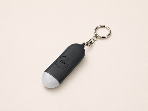 Black Lumae personal safety alarm, back view with three-slot speaker and silver keychain