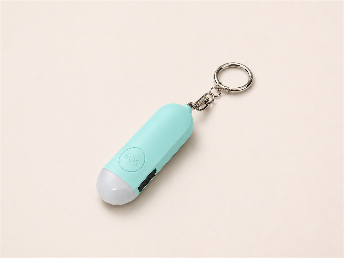 Mint Lumae personal safety alarm, front view with round SOS button and silver keychain